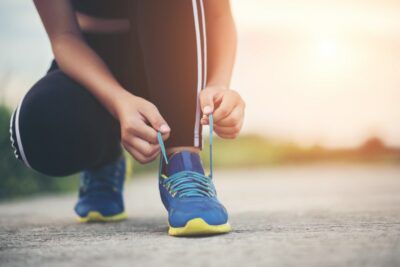 fisioterapia deportiva paciente de clínica gascón abrochándose los cordones para hacer deporte